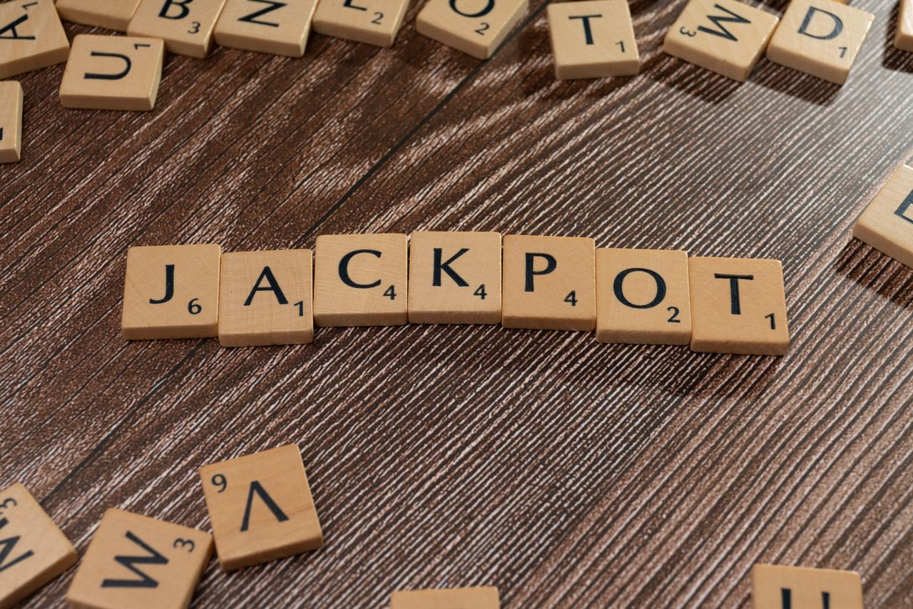 Wooden letter tiles spelling 'JACKPOT' on a textured wooden surface, representing winning or success.